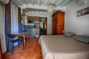 Cet appartement comprend une chambre avec un lit et une table ainsi qu'une cuisine. dans l'établissement Les Bastidieres - Cap Brun, à Toulon