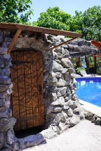 una puerta en una pared de piedra junto a una piscina en Ponto Hotel, en Kobuleti
