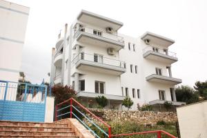 een wit gebouw met een trap ervoor bij Alexandra´s Apartments in Sarandë