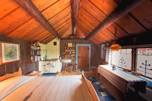 a large room with a wooden ceiling with a table at Egen stuga med delat badrum in Norrtälje