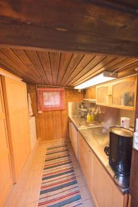 a small kitchen with wooden cabinets and a rug at Egen stuga med delat badrum in Norrtälje