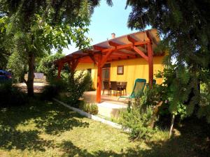 a house with a wooden pergola and a table and chairs at Menta Holiday Home in Badacsonytomaj