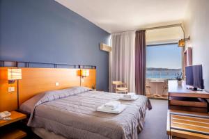 a hotel room with a bed and a television at Spetses Hotel in Spetses