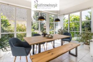 comedor con mesa de madera y sillas en heideferienwohnung en Walsrode