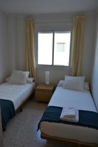 two beds in a room with two windows at AV Andalucía - Tarifa - Parking incluido in Tarifa