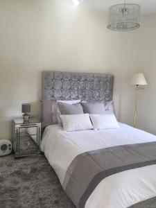 a bedroom with a large white bed with a silver headboard at Fascinating & Luxurious Golf,Mountain & Garden view apartment Porto Banus in Marbella +13 photos