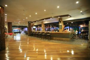 een restaurant met een bar en tafels en stoelen bij Wild Orchid Beach Resort in Olongapo