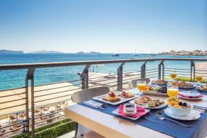 a table with food on a balcony overlooking the ocean at Spetses Hotel in Spetses