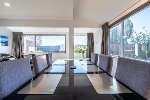 a dining room with a long table and chairs at Wanaka Lake walk 2 town, Lake & Mount View, townhouse in Wanaka