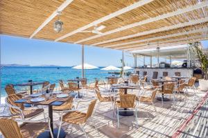 斯佩察島的住宿－斯派賽斯酒店，一个带桌椅的庭院和大海