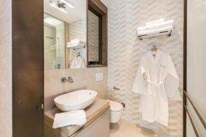 een witte badkamer met een wastafel en een spiegel bij The Garden Suites in Madrid