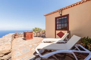 a patio with two lounge chairs and the ocean at Los Hondos in Garafía