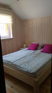 Brīvdienu māja INESE في بيرناتي: غرفة نوم مع سرير كبير مع وسائد وردية