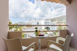 Habitación con mesa, sillas y ventana grande. en Glaros Hotel en Palaiochóra