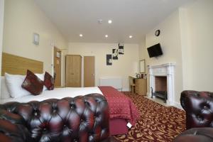 a hotel room with a bed and a couch at Best Western London Ilford Hotel in Ilford