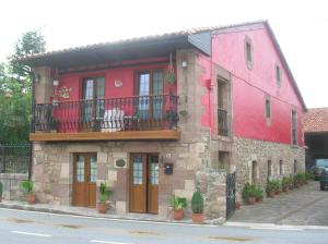 a red building with a balcony on a street at Posada Trisileja in Cos