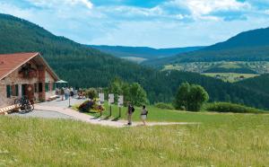 two people walking down a road near a building at Sackmann Wanderhotel in Baiersbronn