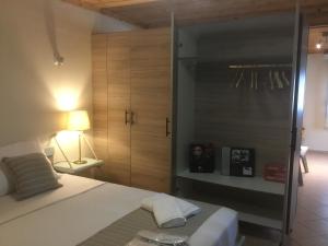 a bedroom with a bed with a closet and a lamp at SUNNY STUDIO in Skala Marion