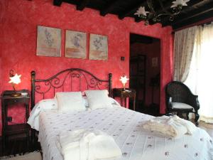 1 dormitorio con 1 cama grande y pared roja en Posada Trisileja en Cos