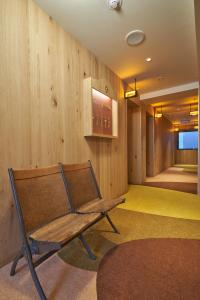 a bench in a room with a wooden wall at cinnamon hotel in Osaka
