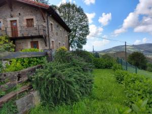 an old stone house in a field of grass at La Casa del Acebal in Solórzano