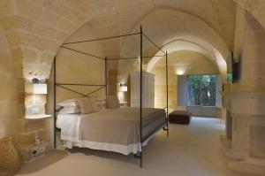 a bedroom with a large bed in a stone room at Masseria Trapana in Lecce