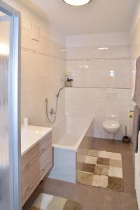 La salle de bains blanche est pourvue d'une baignoire et de toilettes. dans l'établissement Ferienwohnungen Burgwies, à San Martino