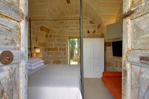 a room with a bed and a glass door at Masseria Trapana in Lecce