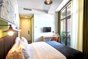 Postel nebo postele na pokoji v ubytování Graphica Tbilisi Hotel