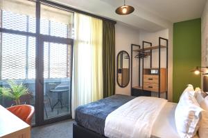 Postel nebo postele na pokoji v ubytování Graphica Tbilisi Hotel