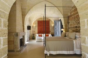 a bedroom with a bed in a room with a fireplace at Masseria Trapana in Lecce
