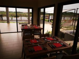 a dining room with wooden tables and red napkins at Au bord de l'eau in Bamako