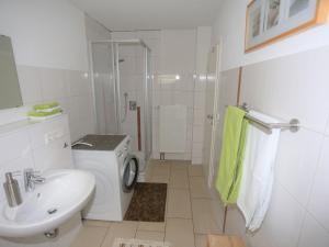 a white bathroom with a sink and a washing machine at Ferienwohnung Rheingeschaut in Bad Bellingen