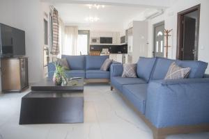 a living room with a blue couch and a table at Villa Miron in Kamilari