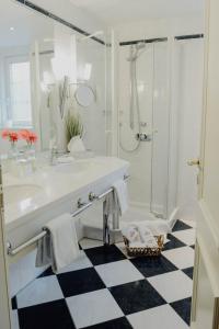 a white bathroom with a sink and a shower at Romantik Hotel Köllners Landhaus in Celle