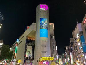 a building with a clock tower in the middle of a city at APA Hotel Shibuya Dogenzakaue in Tokyo