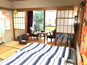 a bedroom with a bed and a living room at Koto House in Yachiyo