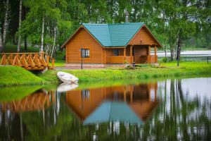 a wooden cabin on the shore of a lake at Eco-Hotel Zaozerye in Zagoski