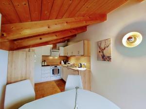 una cocina con armarios blancos y techos de madera. en Apartment Raphaelo Nonntal 8 Apartment, en Berchtesgaden