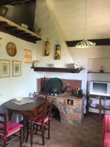 sala de estar con mesa y chimenea de piedra en Romantico Cottage, en Radicofani