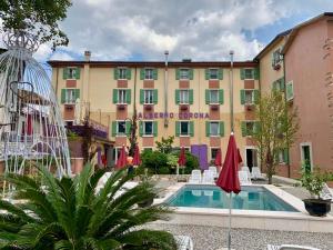 un hôtel avec une piscine en face d'un bâtiment dans l'établissement Hotel Corona, à Spiazzi Di Caprino