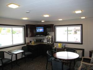 a dining room with tables and chairs and two windows at Travelers Lodge Marshall in Marshall