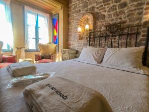 a bedroom with a large bed with a stone wall at Ziyabey Konagi in Ayvalık