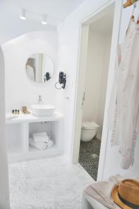 La salle de bains blanche est pourvue d'un lavabo et de toilettes. dans l'établissement Galini Hotel, à Naxos Chora