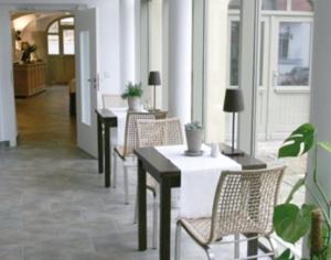 a room with tables and chairs in a building at deckerts Hotel am Katharinenstift in Lutherstadt Eisleben