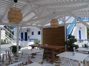 a patio with tables and chairs and awning at Galini Hellenic Hospitality in Patitiri