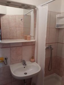 a bathroom with a sink and a mirror and a shower at Apartment Božava - Nena in Božava
