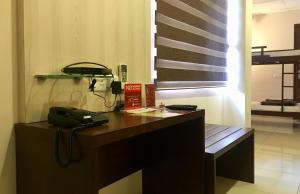 a office with a phone on a desk and a bench at The KAHN Dormitory in Chikmagalūr
