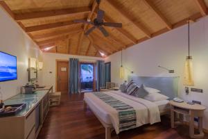 1 dormitorio con 1 cama grande y ventilador de techo en Vilamendhoo Island Resort & Spa, en Dhangethi