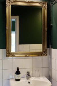 a bathroom with a mirror and a sink at Hotel Kallgården in Järpen